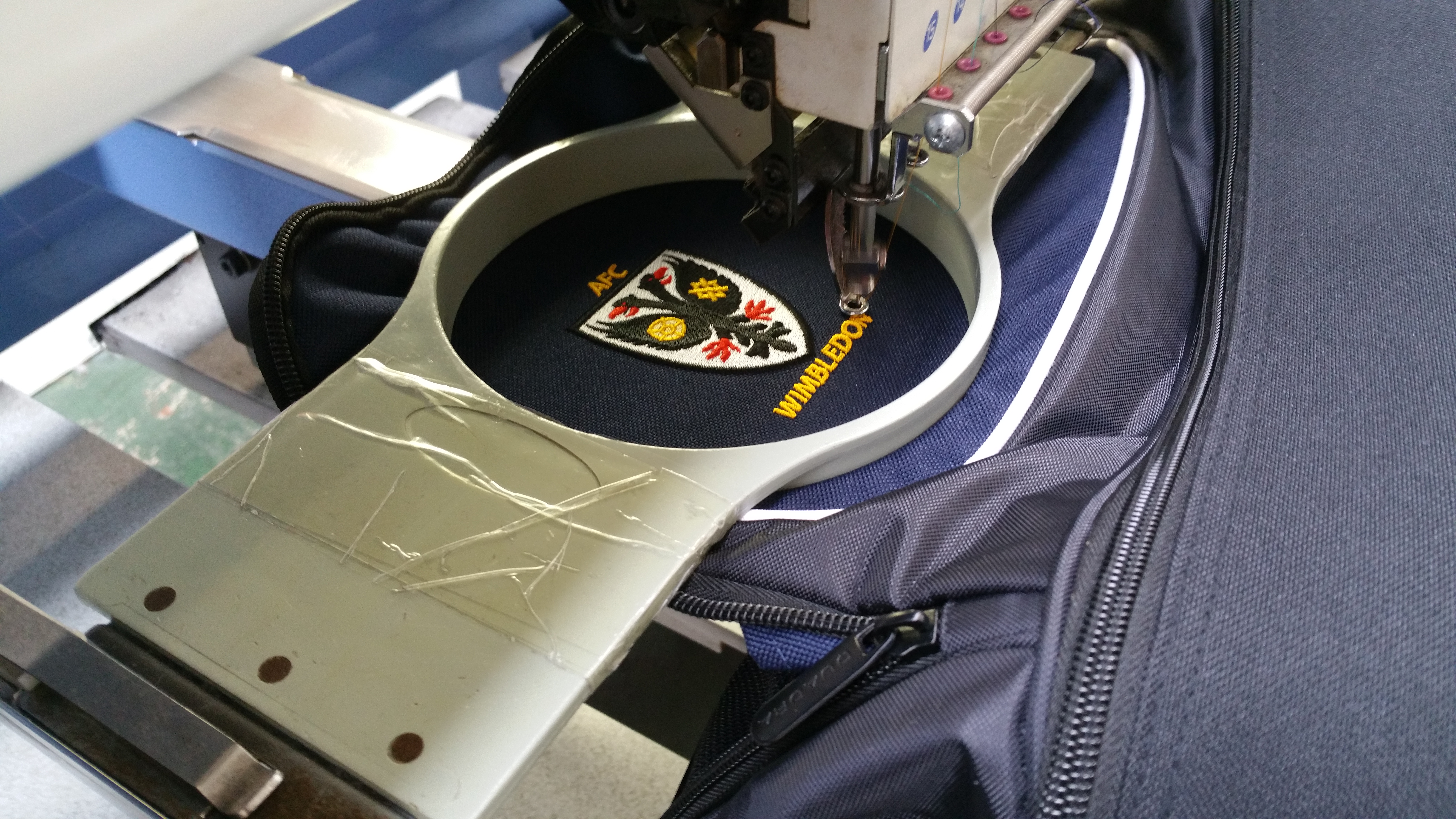 An image of AFC Wimbledon's logo being embroidered on a bag